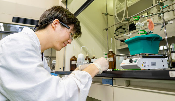 田中研究室にて、がんに有効な化合物の合成に取り組む大出さん