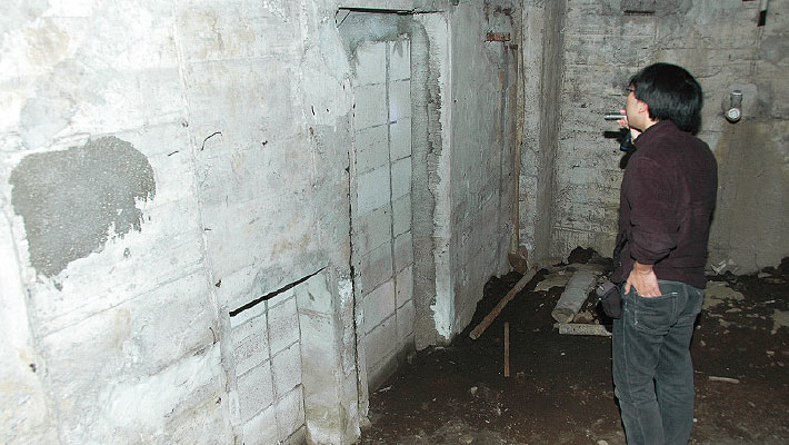 人ひとり通れそうなコンクリートの切れ目と、それを封鎖するブロックの壁。この奥には「シャワー室」があり、かつてはこの入り口と繋がっていたとか。現在では用途不明な地下空間がそこにはありました。